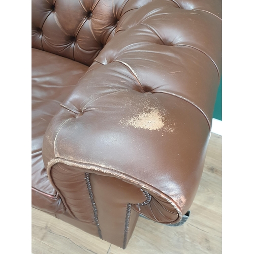 554 - A leather style button upholstered Chesterfield Settee, on turned supports, 7ft W approximately