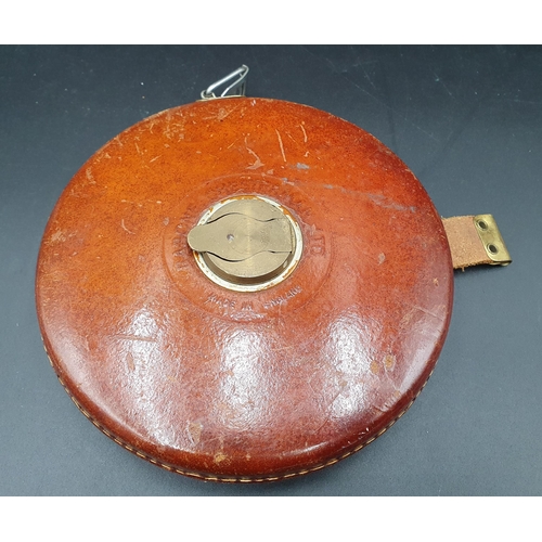 69 - A large 100ft leather cased Tape Measure by Rabone Chesterman Ltd and a pair of glass Candlesticks (... 