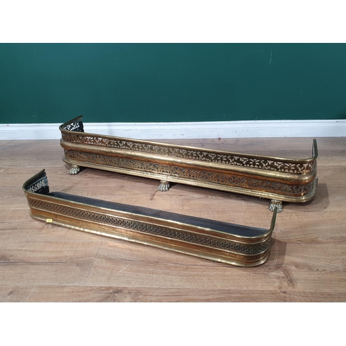 690 - A pierced brass Fender with three paw supports, 3ft 11in W, and another smaller, (R11)