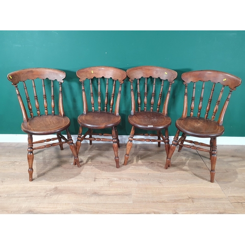 710 - A set of four elm seated Chairs with turned bar backs, circular seats and raised on turned supports ... 