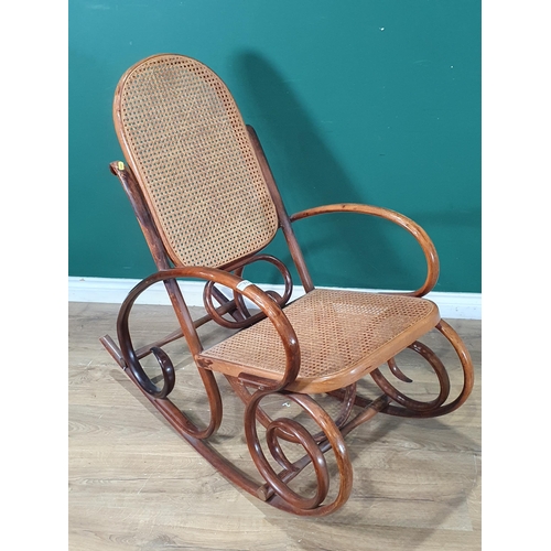 712 - A cane panelled Rocking Chair with scroll design, (R9)