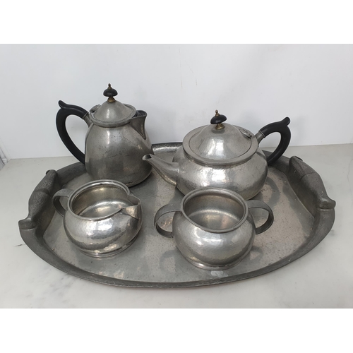 72 - An English pewter four piece Tea Service and oval Tray with hammered design, made by Liberty & Co, T... 