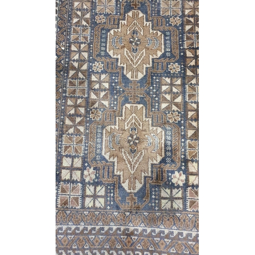 703 - A woollen Rug with three stylised flowers within multiple geometric borders 6ft L x 3ft 4in W (R3)