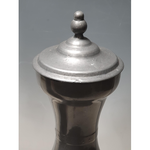1 - A tall pewter Water Jug with acorn finials and bow shaped handle, 1ft 5