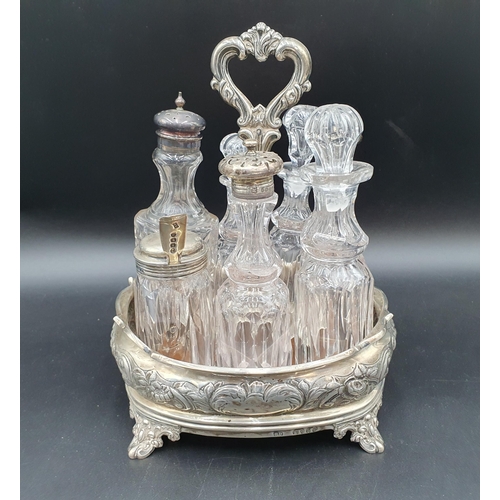 101 - A Victorian silver Cruet with floral and leafage embossing, central handle, fitted seven glass bottl... 
