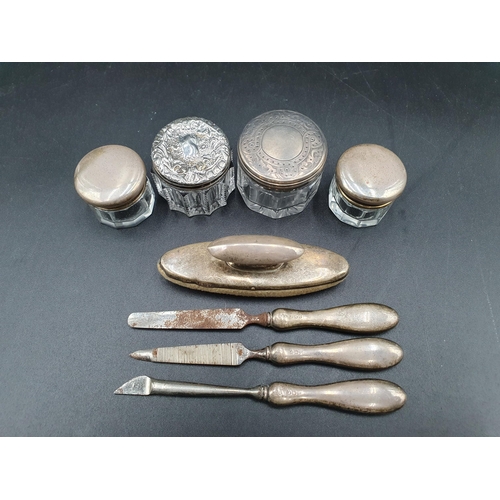 135 - Four silver lidded glass Jars and a four piece silver mounted Manicure Set