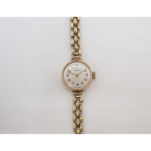 154 - A lady's Marvin Wristwatch the silvered dial with arabic numerals in 9ct gold case on 9ct gold textu... 
