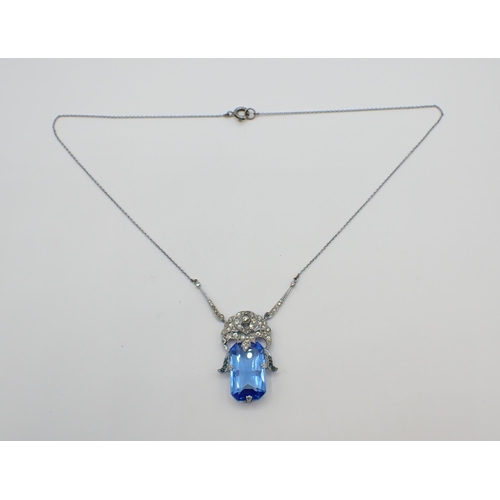 173 - An Art Deco style Necklace set white paste above large blue rectangular glass on fine chain in white... 