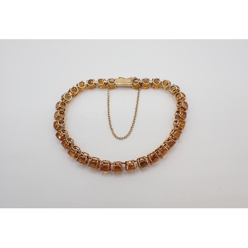 174 - A Citrine line Bracelet claw-set thirty one round stones, clasp stamped 14K, approx 11.70gms