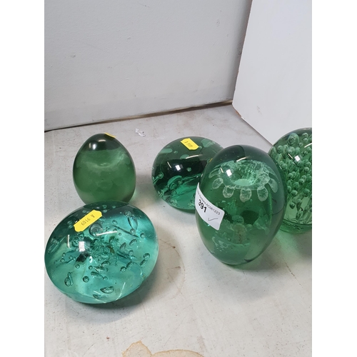 391 - Five green glass Dump Weights two with flower decorations. (R5).