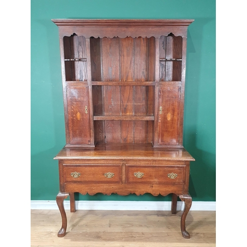 473 - An oak Dresser and Rack, the rack with open shelves flanked by pair of cupboards, the base fitted tw... 