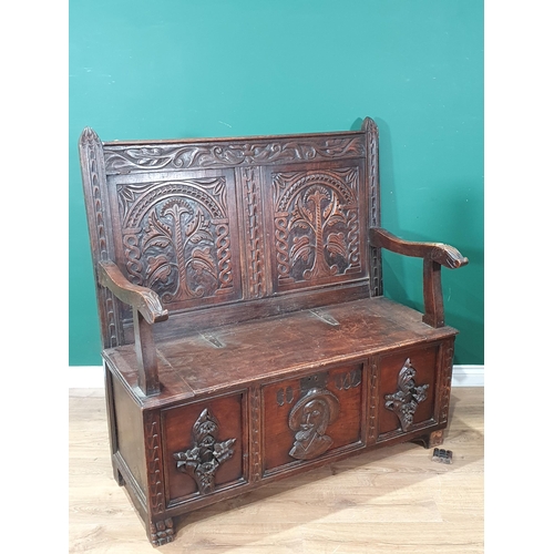 474 - An oak Box Settle with carved panel back, lift up seat, above three panel front with carved applied ... 