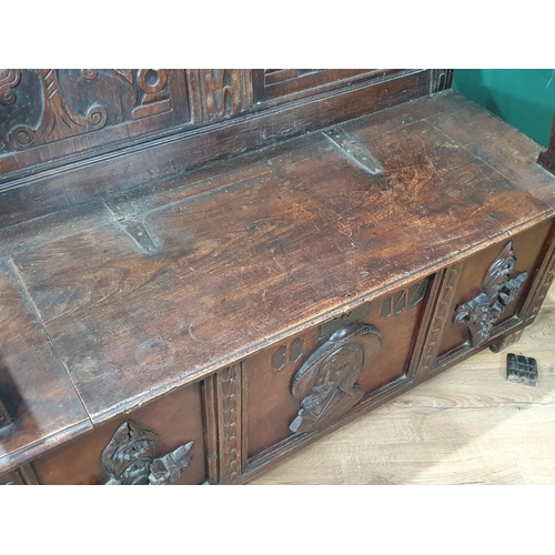 474 - An oak Box Settle with carved panel back, lift up seat, above three panel front with carved applied ... 