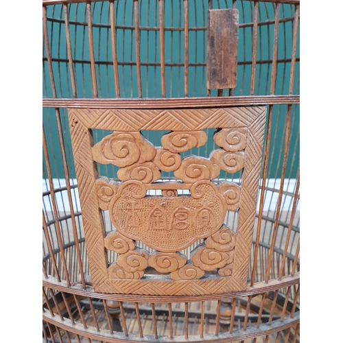 495 - A decorative Oriental Hanging bamboo Birdcage with carved door and three carved supports, 2ft 6