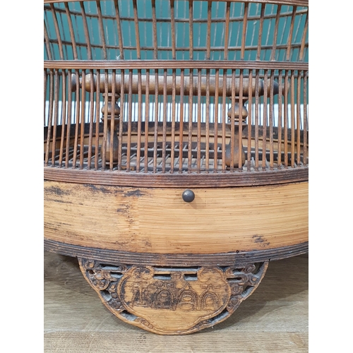 495 - A decorative Oriental Hanging bamboo Birdcage with carved door and three carved supports, 2ft 6