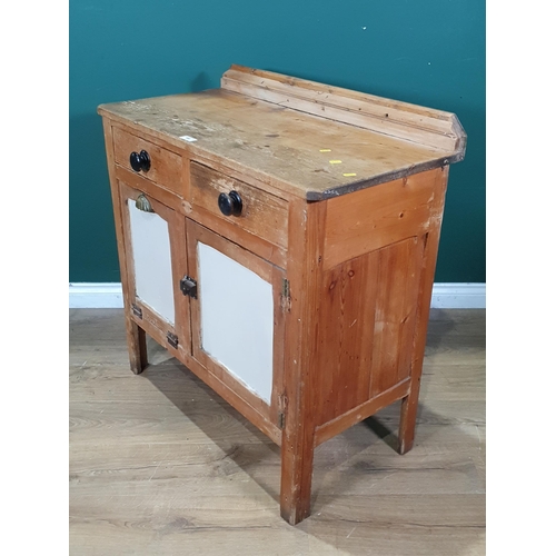 498 - A rustic pine Kitchen Cupboard, fitted two drawers above a single cupboard door and a fall front was... 