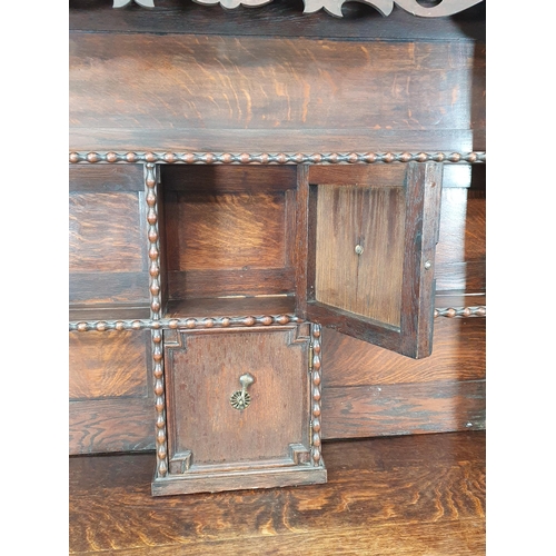 574 - An oak Dresser and Rack, the rack with pierced shaped frieze with open shelves, and two central cupb... 