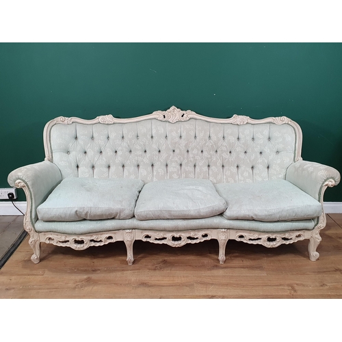 577 - A cream and green button back French Style three seater Settee with carved floral and leafage decora... 