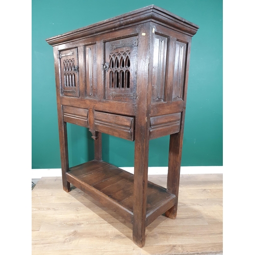 581 - An oak Cupboard in the 16th Century style fitted with pair of pierced Gothic arched doors above two ... 