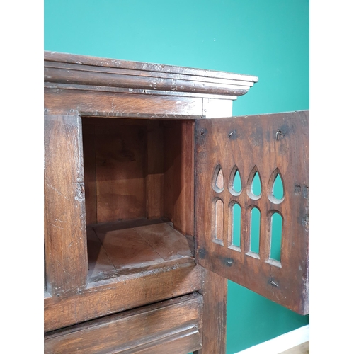 581 - An oak Cupboard in the 16th Century style fitted with pair of pierced Gothic arched doors above two ... 