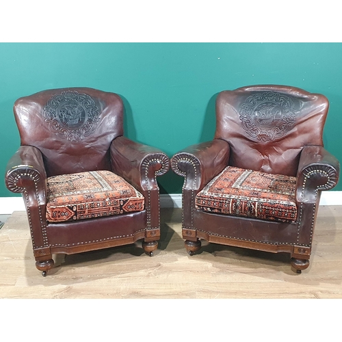 598 - A pair of brown leather Armchairs with designs of Medieval ships to back and carpet covered seats 2f... 