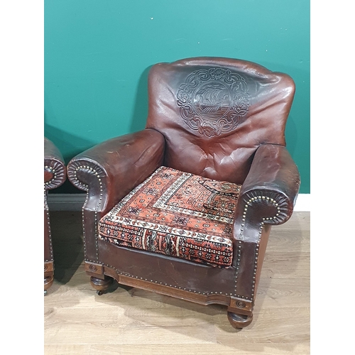 598 - A pair of brown leather Armchairs with designs of Medieval ships to back and carpet covered seats 2f... 