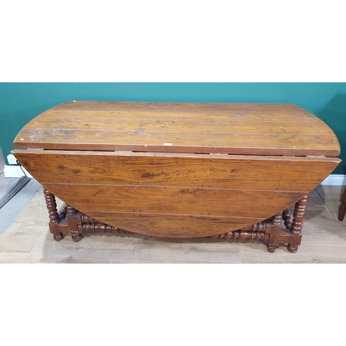 628 - A large elm Gateleg Table with oval top and ring turned supports 6ft 8in x 6ft 9in open (R9)