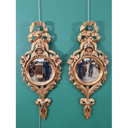 629 - A pair of gilt framed Wall Mirrors with circular plates, with ribbon and flower decorated frames, 3f... 