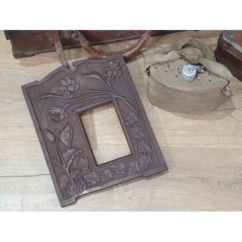 750 - A leather Case containing a small leather case, a canvas covered water Canteen, and a carved Picture... 