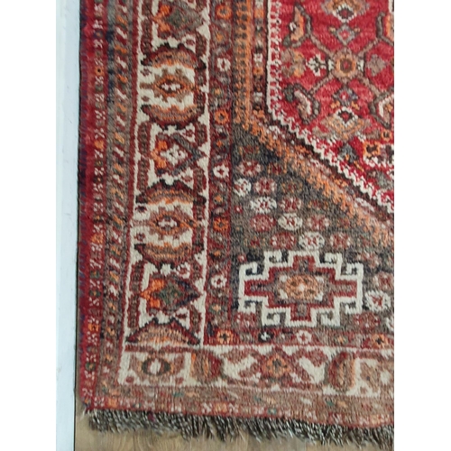 276 - A Persian Rug with multiple borders and large central medallion on a red ground, 6ft 4in x 4ft 6in