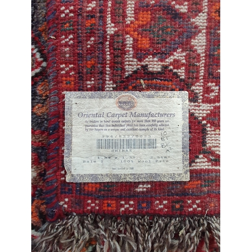 276 - A Persian Rug with multiple borders and large central medallion on a red ground, 6ft 4in x 4ft 6in