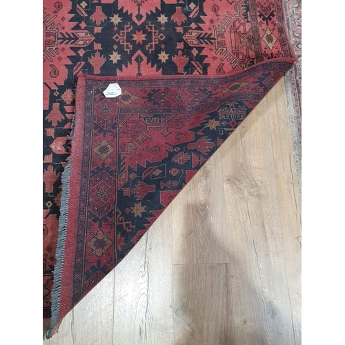 280 - A Wool Rug made in Pakistan with stylised motifs on a red ground 7ft 1in x 4ft 3in