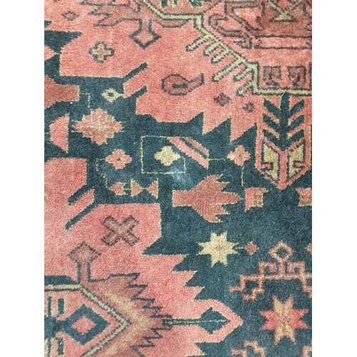 280 - A Wool Rug made in Pakistan with stylised motifs on a red ground 7ft 1in x 4ft 3in