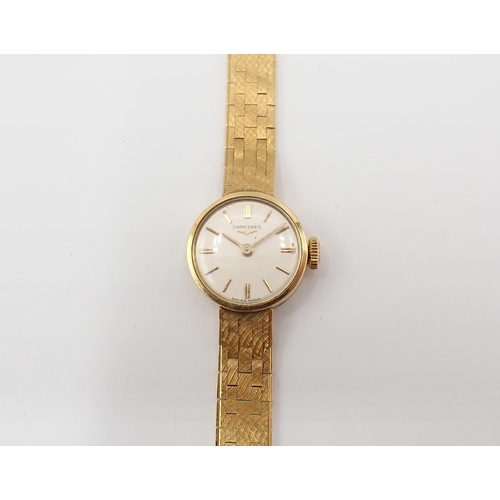 105 - A lady's 18ct gold Longines Wristwatch the ivory coloured dial with hourly baton markers on integral... 