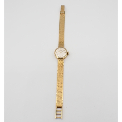 105 - A lady's 18ct gold Longines Wristwatch the ivory coloured dial with hourly baton markers on integral... 