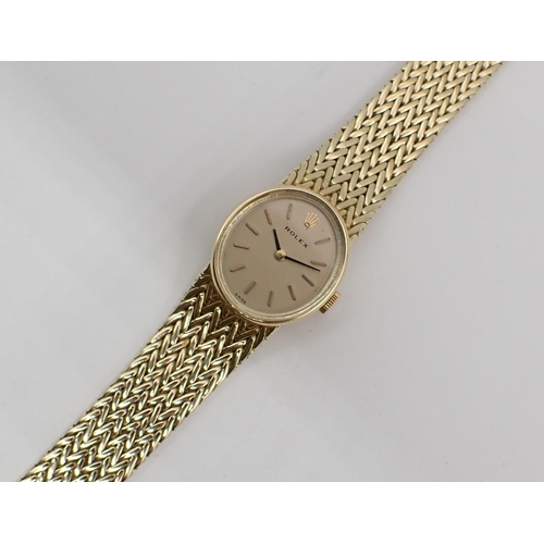 110 - A lady's Rolex manual Wristwatch the oval champagne dial with hourly baton markers on integral 14ct ... 