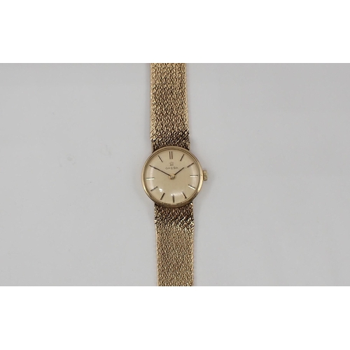 128 - A lady's Omega Wristwatch the champagne dial with hourly baton markers in 9ct gold case, case width ... 