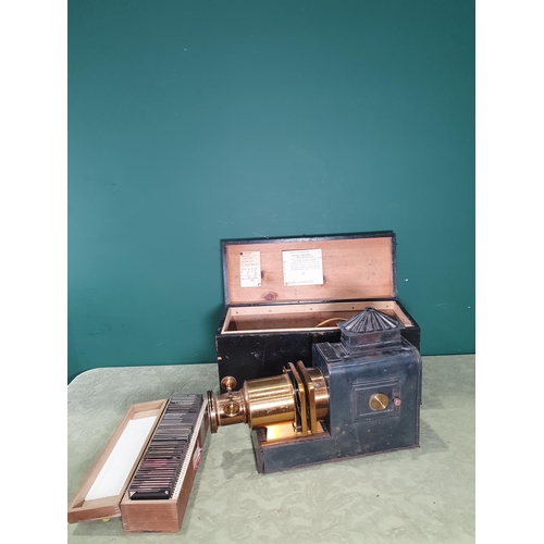 1381 - A brass and painted tin Magic Lantern in box with a case of magic lantern slides