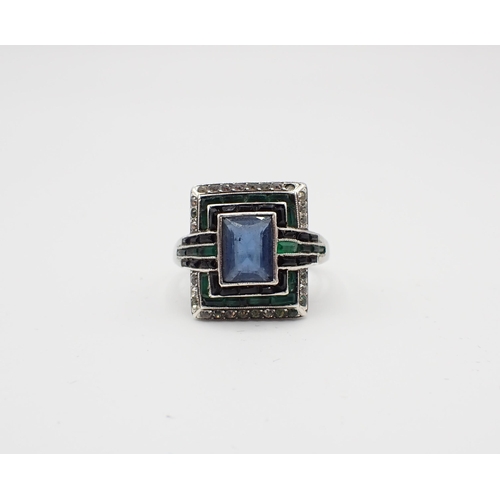 154 - An Art Deco Cocktail Ring millegrain-set blue, green and white paste to the rectangular plaque, in w... 