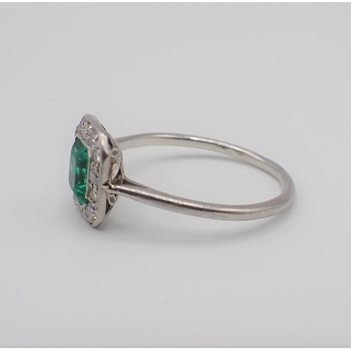 181 - An Art Deco Emerald and Diamond Cluster Ring millegrain-set step-cut emerald within a frame of brill... 