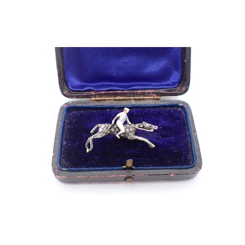 222 - A Diamond and Enamel Horse and Jockey Brooch the jockey enamelled with blue and white hooped colours... 