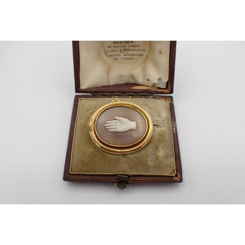 223 - A Victorian carved shell Cameo Brooch depicting a hand in simple gold frame marked 16, 30mm x 26mm, ... 