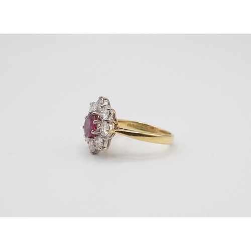 224 - A Ruby and Diamond flower Cluster Ring claw-set round ruby within a frame of eight brilliant-cut dia... 