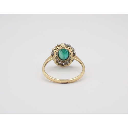 225 - An Emerald and Diamond Cluster Ring millegrain-set oval-cut emerald within a frame of baguette and b... 