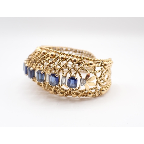 229 - A Gubelin Sapphire and Diamond Bangle of graduated bombé form corner claw-set a row of graduated ste... 