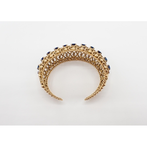 229 - A Gubelin Sapphire and Diamond Bangle of graduated bombé form corner claw-set a row of graduated ste... 