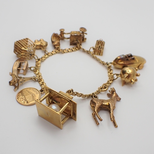 230 - A fancy link 18ct gold Bracelet suspending approx twelve charms, some 9ct some 18ct gold, approx 36g... 