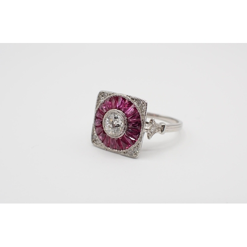 237 - An Art Deco style Diamond and Ruby Target Ring millegrain-set old-cut diamond within a round frame o... 