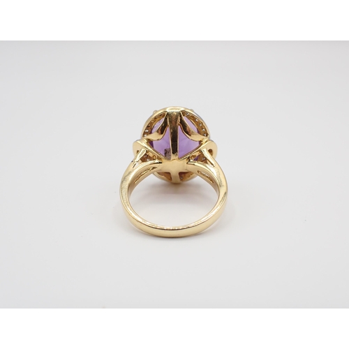 239 - An Amethyst and Diamond Cluster Ring claw-set oval-cut amethyst within a frame of pavé-set brilliant... 