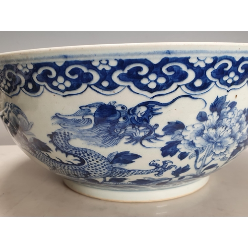 351 - A 19th Century Chinese large blue and white Bowl decorated dragons and flowers in a landscape with i... 